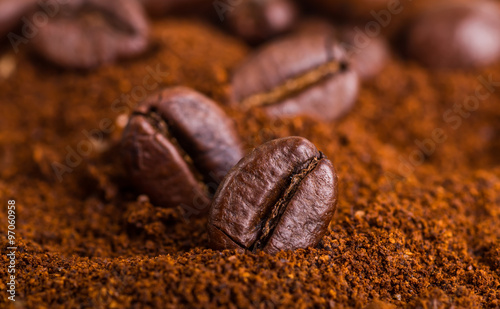 Closeup of two coffee beans at roasted coffee heap. Coffee bean