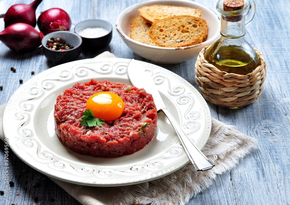 Steak tartar with egg yolk, red onion, capers, spicy sauce, sea salt, pepper and olive oil. Steak tartar with egg yolk, red onion, capers, spicy sauce, sea salt, pepper and olive oil.