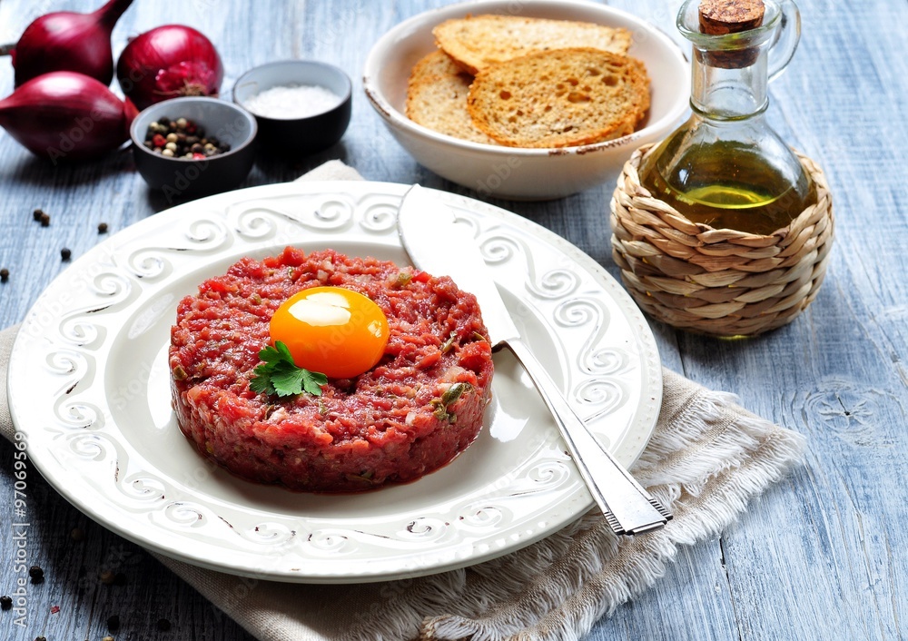 Steak tartar with egg yolk, red onion, capers, spicy sauce, sea salt, pepper and olive oil.