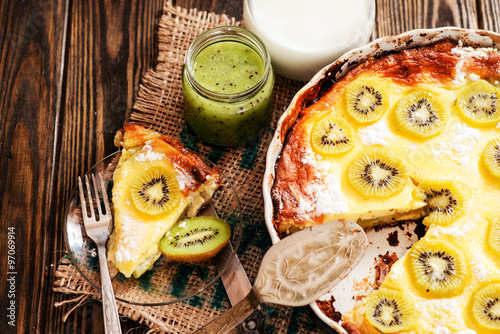  home baked pie with kiwi, milk and jam on a wooden background