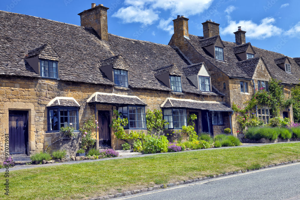 Road in an English village with golden stone traditional cottages Road in an English village with golden stone traditional cottages
