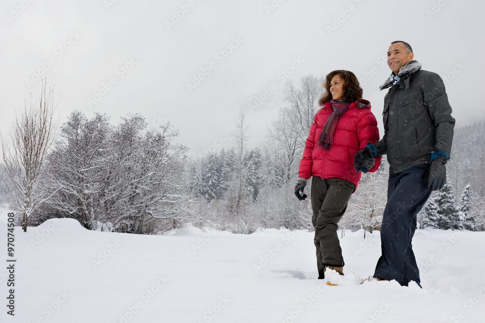 Mature couple walking through snow