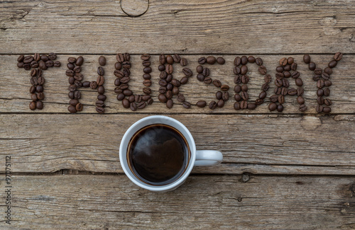 Cup of coffee on wooden background and THURSDAY coffee beans photo