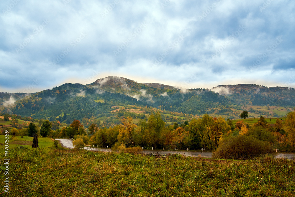 Naklejka premium Mountain landscape with clouds and colorful trees