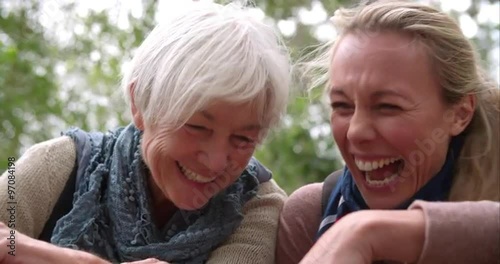 Mother and adult daughter laughing outdoors, slow motion photo