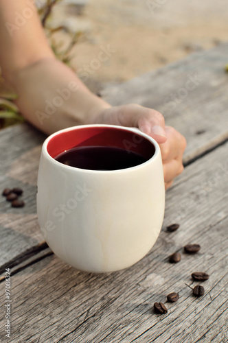 Women hand holding a coffee cup, too soft focus
