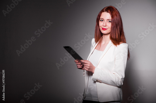 red businesswoman holding tablet and showing thumbs up isolated over white