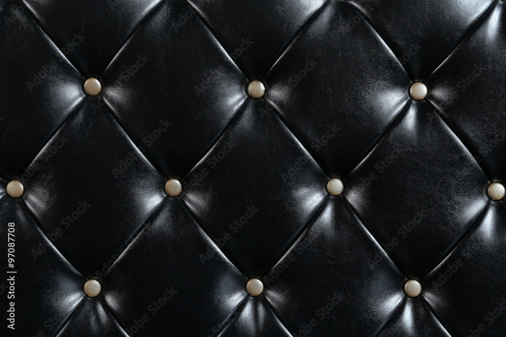 Naklejka premium Black leather upholstery with gold buttons