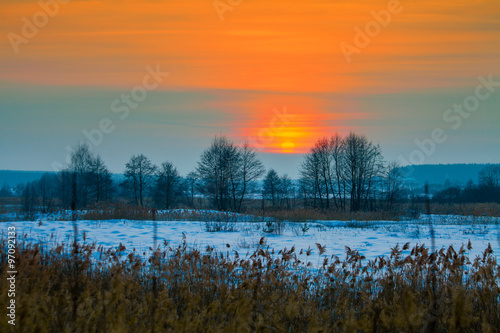 Magic winter sunset over snowy field