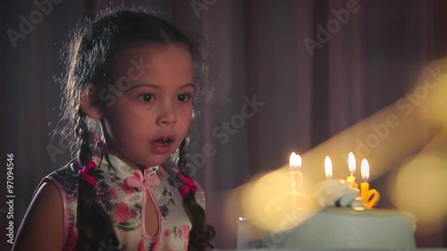 girl blows out the candles cake