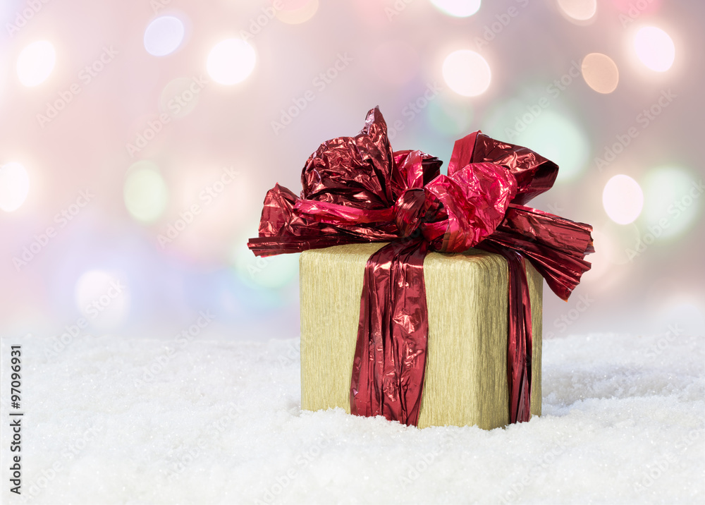 Fototapeta premium Gift box with a red ribbon on snow