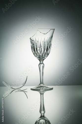 Broken crystal  glass with reflection on white illuminated backg