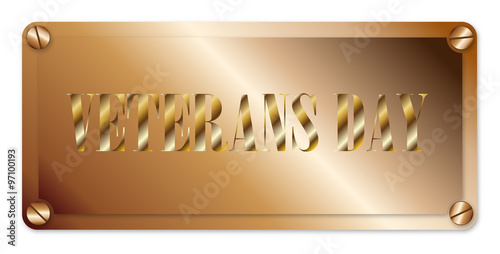 A brass plaque displaying the text veterans day