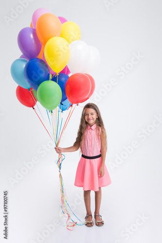 Pretty little girl standing with balloons