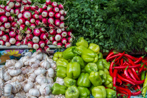  Red and green peppers, parsley and dill, radish and garlic on the counter market