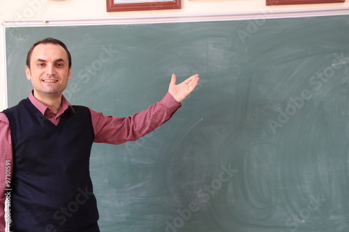 The teacher in the classroom on greenboard background.