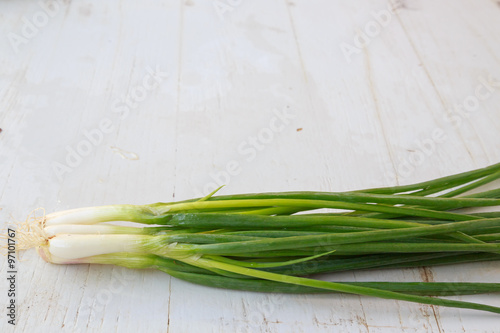 bunch of spring onions on wooden