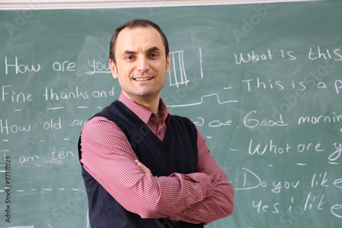 The teacher in the classroom on greenboard background.