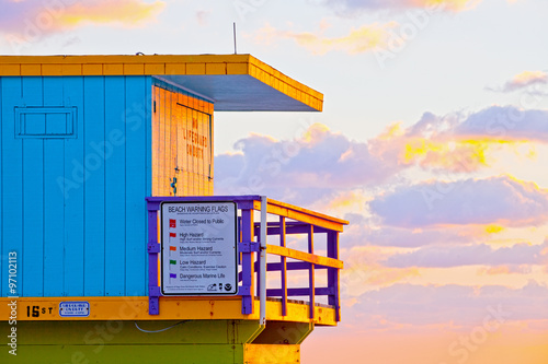 Sunrise in Miami Beach Florida, closeup with a colorful lifeguard house in a typical Art Deco architecture, at sunrise with ocean and sky in the background. © FotoMak
