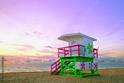 Sunrise in Miami Beach Florida, with a colorful lifeguard house in a typical Art Deco architecture, at sunrise with ocean and sky in the background.
