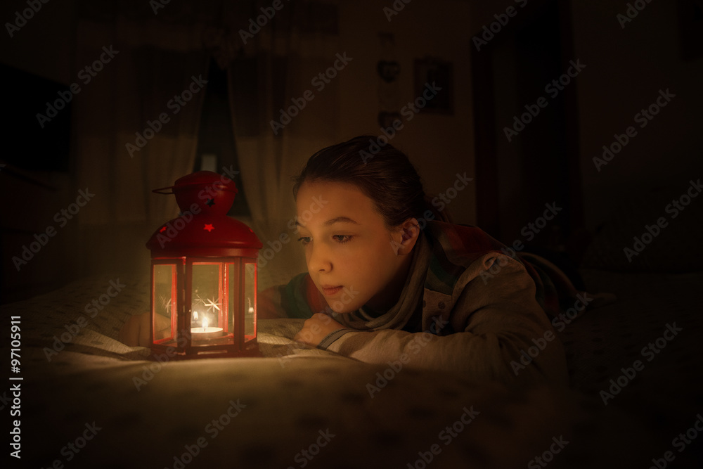 Bambina sognante davanti ad una lampada