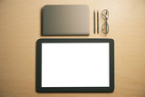 Blank digital tablet screen with diary, pens and eyeglasses on t