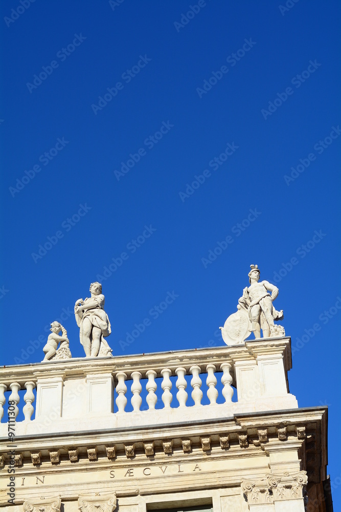 The statues and the mythology in the blue sky.