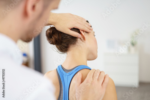 physiotherapeut behandelt eine patientin mit nackenschmerzen photo