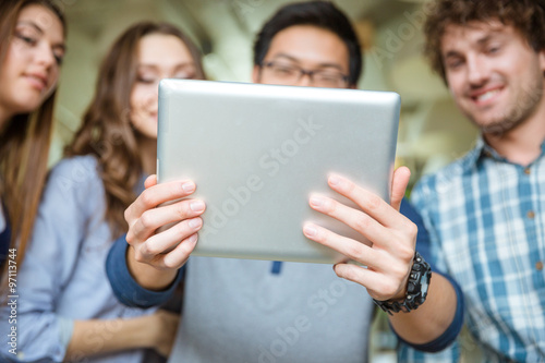 Tablet is used by group of young friends