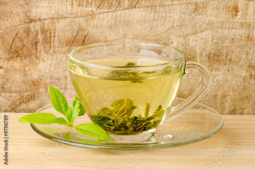 The cup of hot green tea (Healthy drink) on wooden background