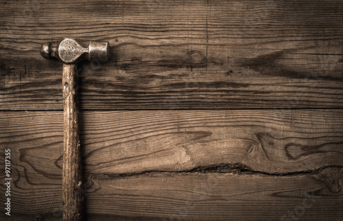 Old retro hammer on wooden workbench