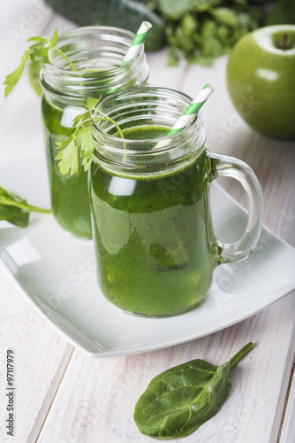 Bebida green smoothie o batido verde energético con frutas hojas de espinacas y verduras para una dieta sana en mason jar con pajita en espiral