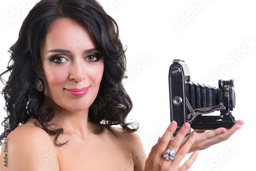 Beautiful brunette woman holding a vintage camera isolated