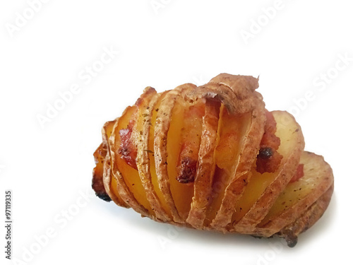 Hasselback or Swedish Potato with Bacon and onion spiced with herbs over white background, Shallow focus