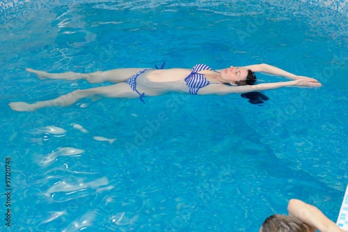 Water Yoga; a pregnant woman does her yoga exercises at the pool