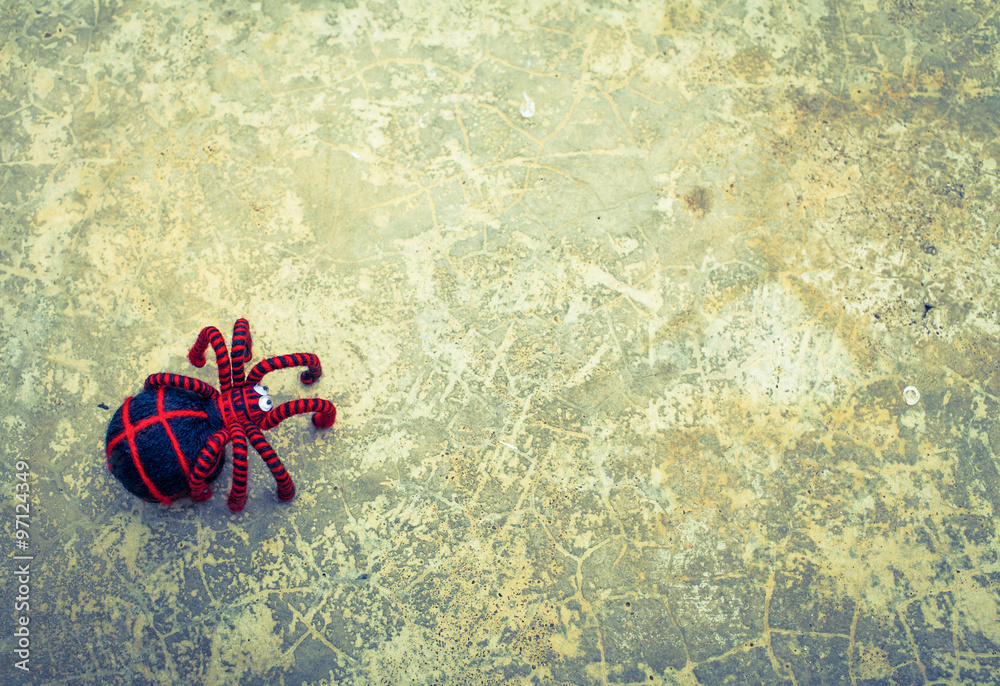 Naklejka premium Red spider on abstract pattern cement floor background