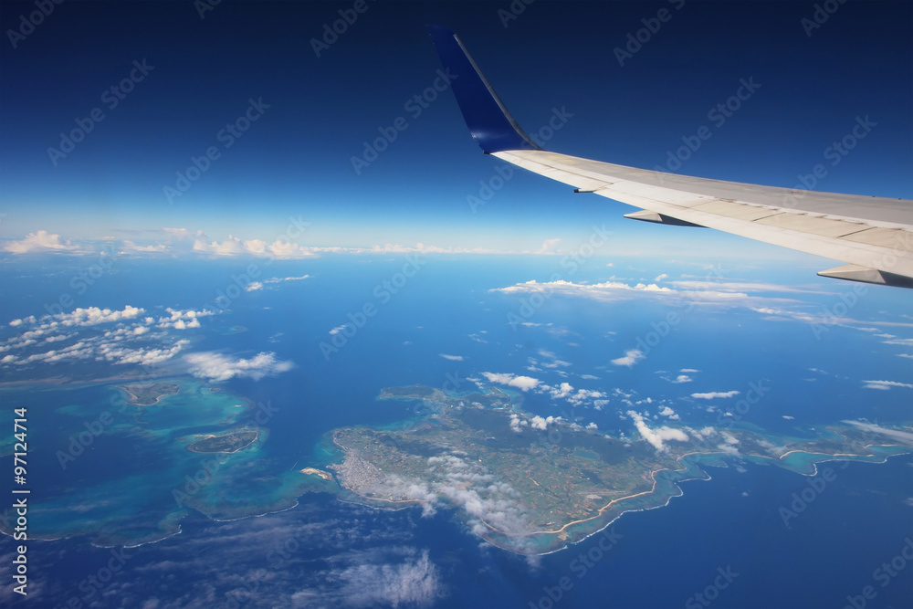 Obraz premium Wing of airplane above many islands