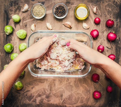 cooking  concept female hands, stirred igridienty for cooking burger on wooden rustic background top view close up photo