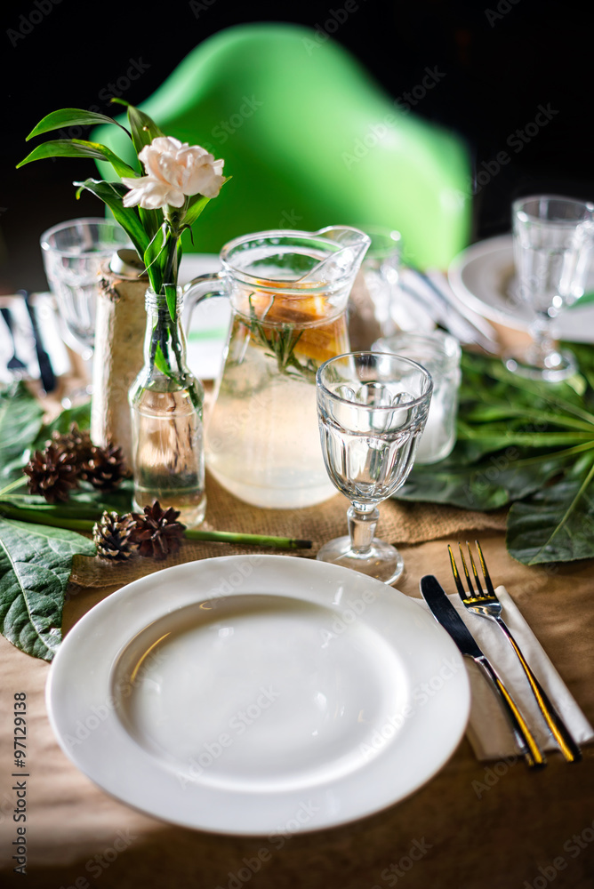 A carafe of fruity beverage with mint and lemon on a decorated table ready for dinner. Beautifully decorated table set for wedding or another event in the restaurant. A carafe of fruity beverage with mint and lemon on a decorated table ready for dinner. Beautifully decorated table set for wedding or another event in the restaurant.