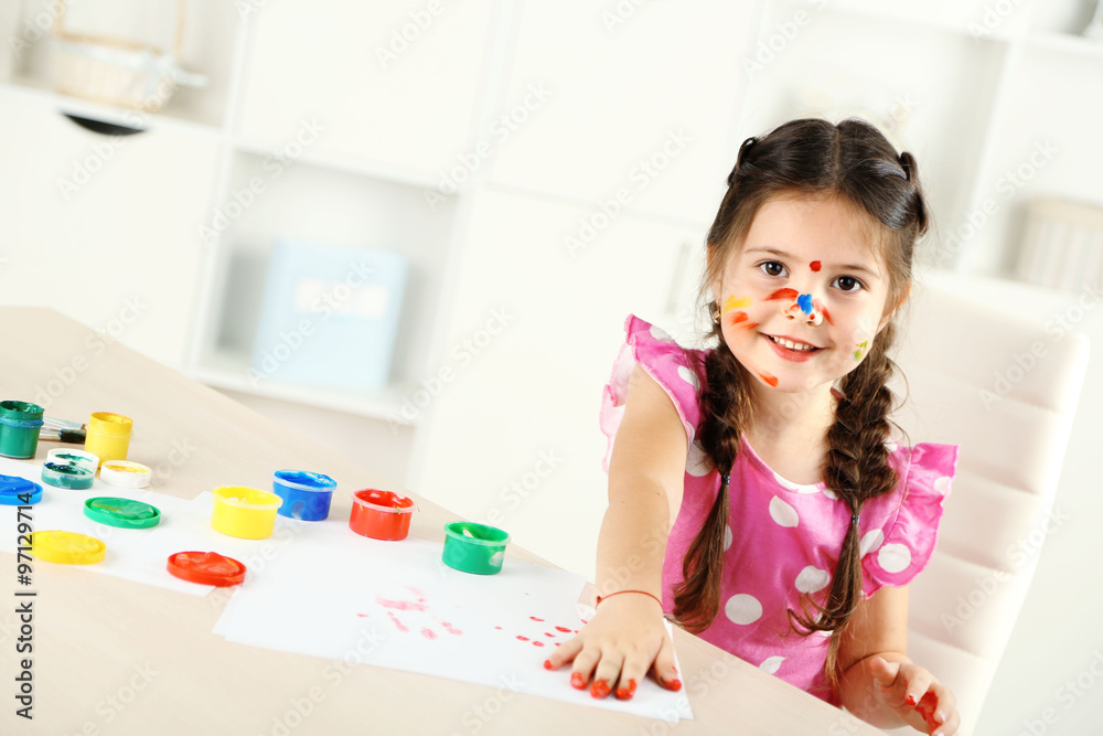 Cute little girl painting picture on home interior background Cute little girl painting picture on home interior background