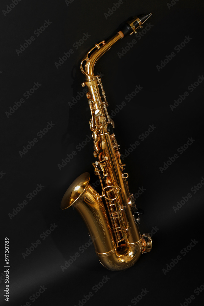 Naklejka premium Beautiful golden saxophone on black background