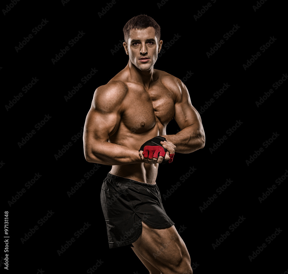 Shirtless bodybuilder holding dumbell and showing his muscular a