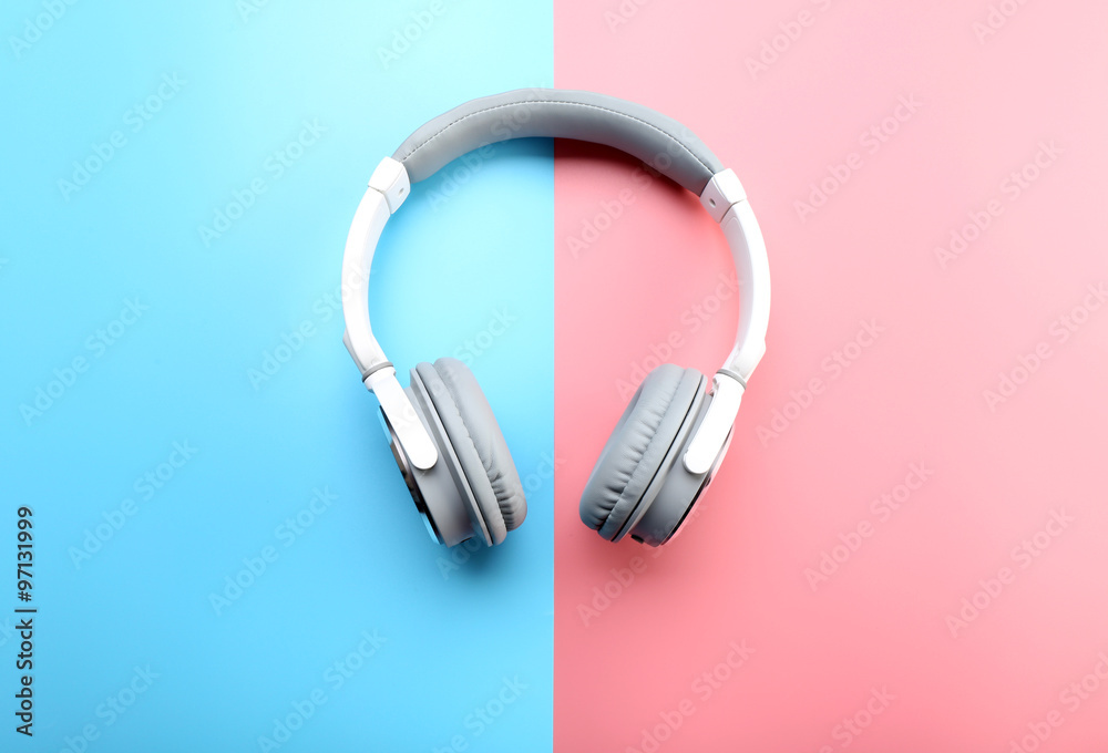 Wireless white and grey headphones on pink-blue background Wireless white and grey headphones on pink-blue background