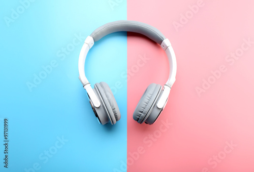 Wireless white and grey headphones on pink-blue background