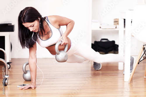 junge Frau macht Fitnessübung mit Kettlebells