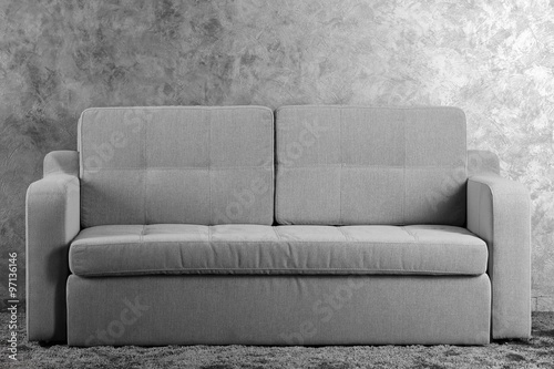 Comfortable sofa on grey wall background