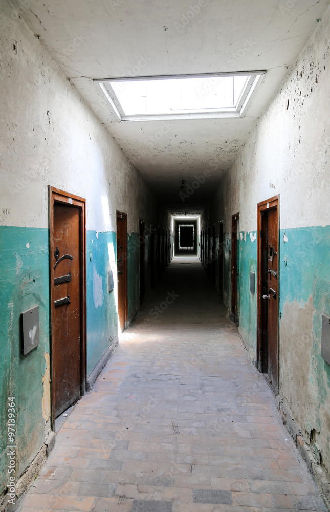 Old corridor with doors as if in a hospital or prison.