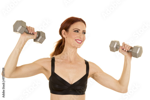 woman black sports bra pressing weights happy