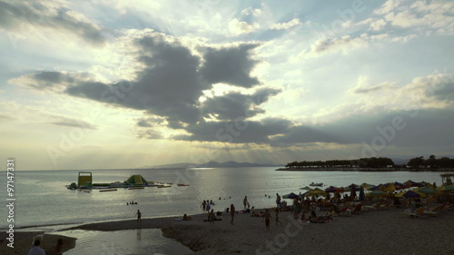 4K establishing wide shot of people on a greek beach in Athens, at sunset/dusk photo