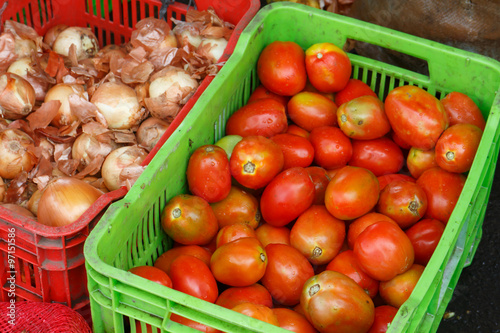 tomatoes and onions on plastic box from market